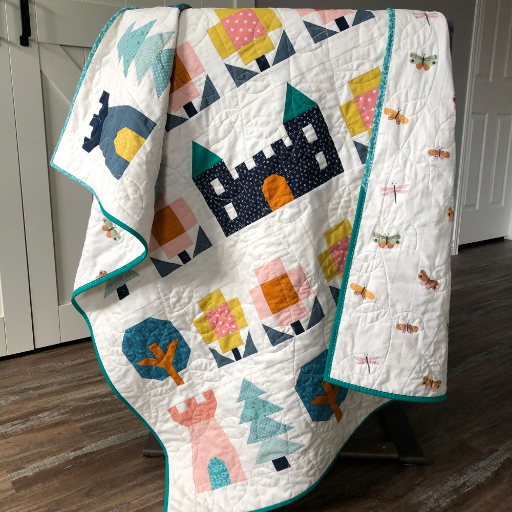 Little Kingdom baby quilt hanging over chair