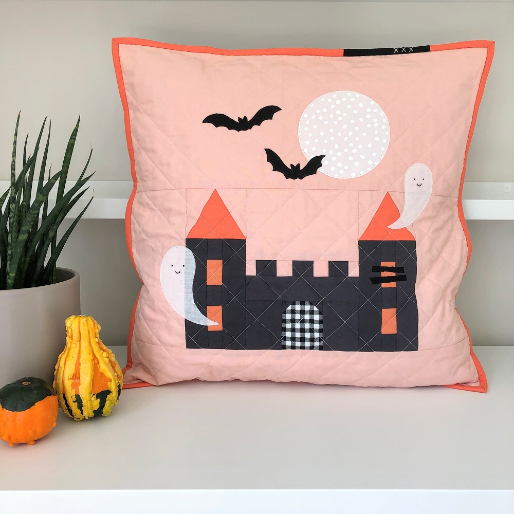 Little Kingdom Halloween pillow with ghost and bat details, coral colourway