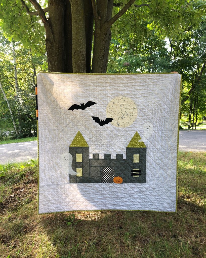 Apples & Beavers, "Little Kingdom" jumbo castle baby quilt in front of tree