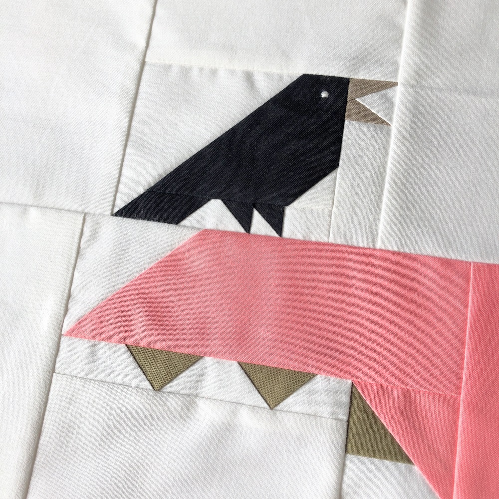 Close-up of crow quilt block, positioned such that the bird sits on a dragon's tail