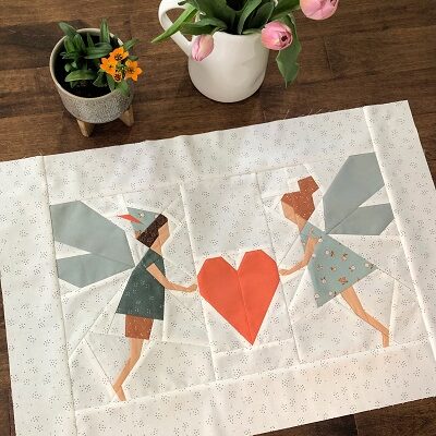 Two little fairies carrying a heart