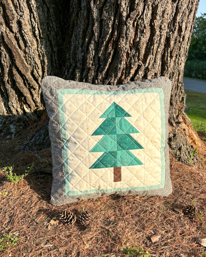 Apples & Beavers: Evergreen pillow cover leaning against big tree trunk