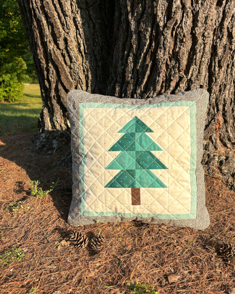 Apples & Beavers: Evergreen pillow cover leaning against big tree trunk